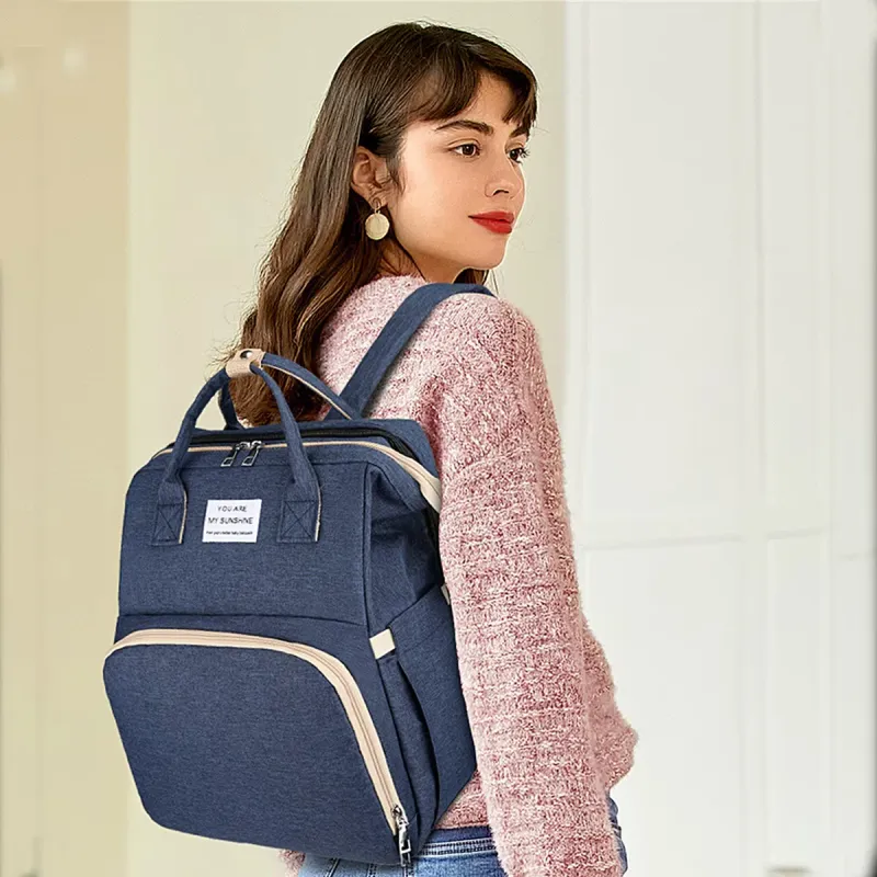 woman wearing a blue diaper bag rucksack backpack